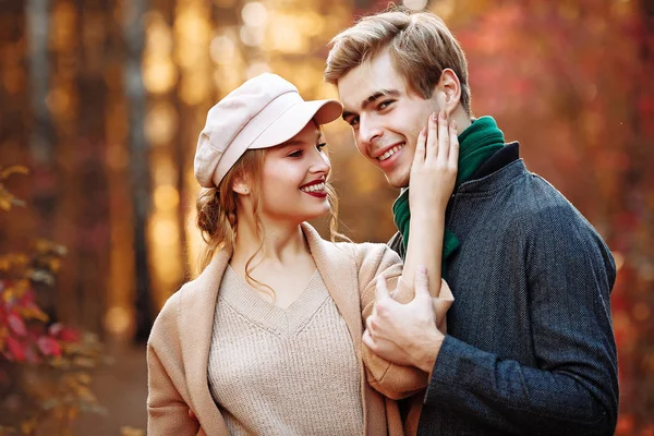 Happy, couple in love hugs and smiles on the street, autumn, green scarf and cap, man and woman on a date, valentines day. walk in the park — Stock Photo, Image