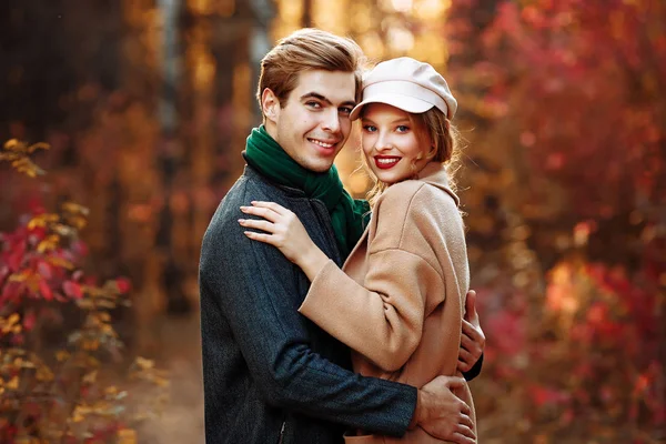 Happy, couple in love hugs and smiles on the street, autumn, green scarf and cap, man and woman on a date, valentines day. walk in the park — Stock Photo, Image