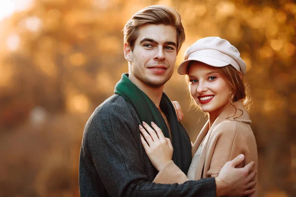 Feliz, casal no amor abraços e sorrisos na rua, outono, lenço verde e boné, homem e mulher em um encontro, dia dos namorados. caminhar no parque — Fotografia de Stock