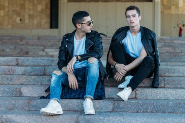 Şehirde poz veren güzel ve çekici bir adam. Siyah gözlüklerle şehirde dolaş. İletişim. arkadaşlarla buluş.