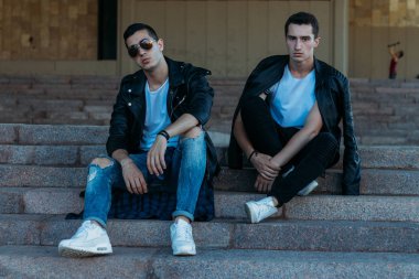 Şehirde poz veren güzel ve çekici bir adam. Siyah gözlüklerle şehirde dolaş. İletişim. arkadaşlarla buluş.