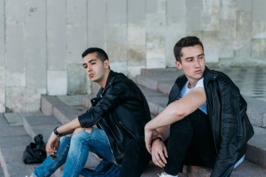 Şehirde poz veren güzel ve çekici bir adam. Siyah gözlüklerle şehirde dolaş. İletişim. arkadaşlarla buluş.