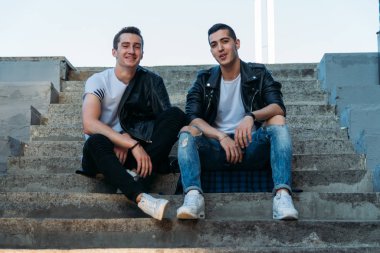 Şehirde poz veren güzel ve çekici bir adam. Siyah gözlüklerle şehirde dolaş. İletişim. arkadaşlarla buluş.