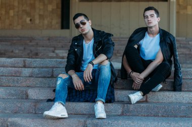 Şehirde poz veren güzel ve çekici bir adam. Siyah gözlüklerle şehirde dolaş. İletişim. arkadaşlarla buluş.