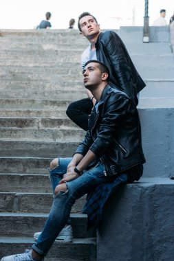 Şehirde poz veren güzel ve çekici bir adam. Siyah gözlüklerle şehirde dolaş. İletişim. arkadaşlarla buluş.