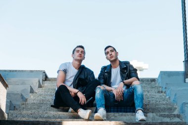 Şehirde poz veren güzel ve çekici bir adam. Siyah gözlüklerle şehirde dolaş. İletişim. arkadaşlarla buluş.