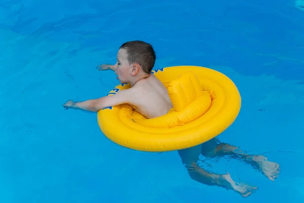 Der Junge Schwimmt Wasser Einem Aufblasbaren Gelben Kreis Pool — Stockfoto
