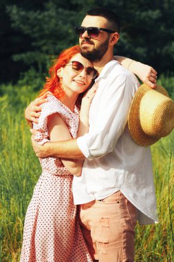 Mutlu, birbirine aşık bir çift, kızıl saçlı kız. Öpüşmeye bir dakika. Yazın cazibe ve cinsellik güneş gözlüğü.