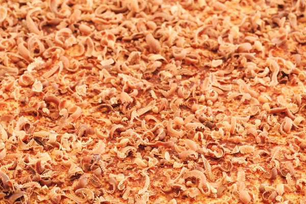 Close up of fine chocolate chips and curls chopped by hand on cake texture. Chocolate flakes, extreme macro. Best picture of tasty chocolate curls shavings. — Stock Photo, Image