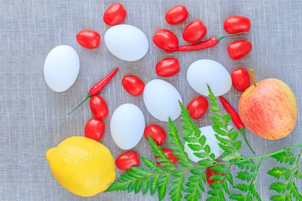 Easter composition: eggs, tomatoes, chilli pepper, apple and lemon on the textured background. Vegetables and fruits in Eastern composition picture. Colorful Eastern composition & art concept. Best picture composition for the Eastern background. — Stock Photo, Image