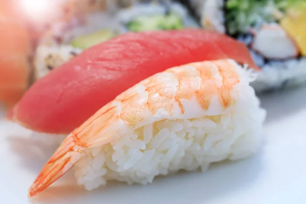 Garnelen mit Reis in Großaufnahme. Sashimi Sushi in Großaufnahme. Teller mit Garnelen vorhanden. frisches und köstliches Maki und Nigiri Sushi und Sake Glas. Stockbild