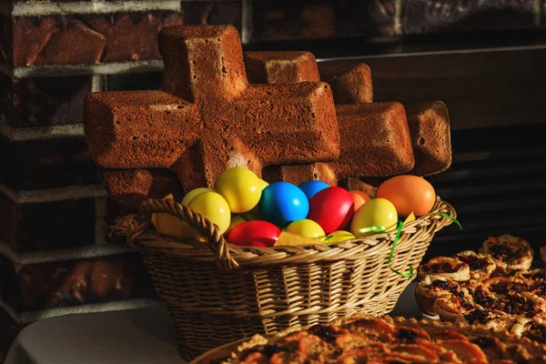 Paskalya yumurtası ve geleneksel bayram yemeği olarak pişirilmiş çapraz ekmek. Paskalya pastası, çapraz çörekler ve yumurtalar yakın plan. Ev yapımı sıcak haç çörekleri Paskalya zamanı için hazır..