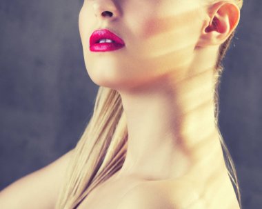 Genç kadın moda makyaj ile kısmi görünümü gri arka plan üzerinde