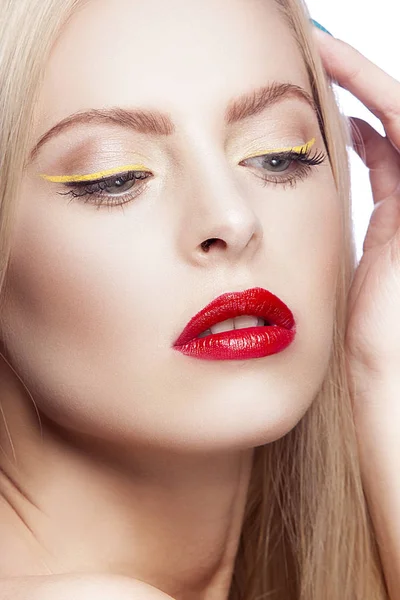 Portrait of woman with modern yellow eyeliner and red lips