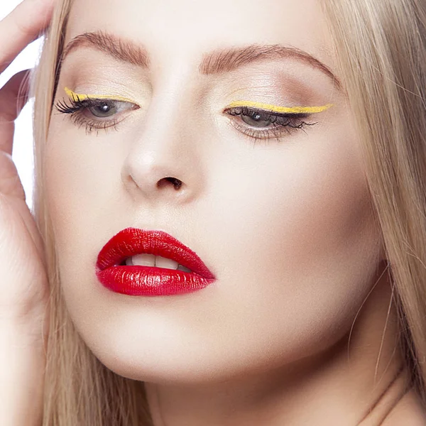 Portrait of woman with modern yellow eyeliner and red lips