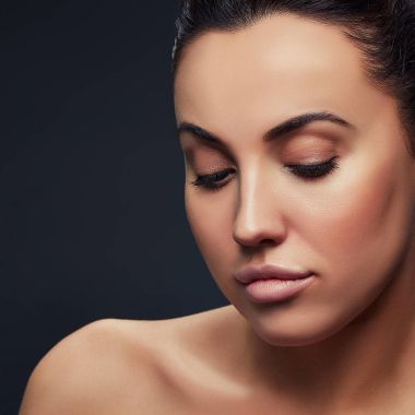 Koyu arka plan üzerinde doğal makyaj ile esmer kadın portresi 