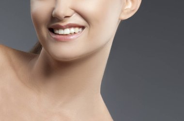 Kadın portre gri arka plan üzerinde gülümseyen kısmi görünümü