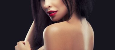 Siyah zemin üzerine kırmızı dudaklar makyaj ile şehvetli esmer kadın portresi kırpılmış