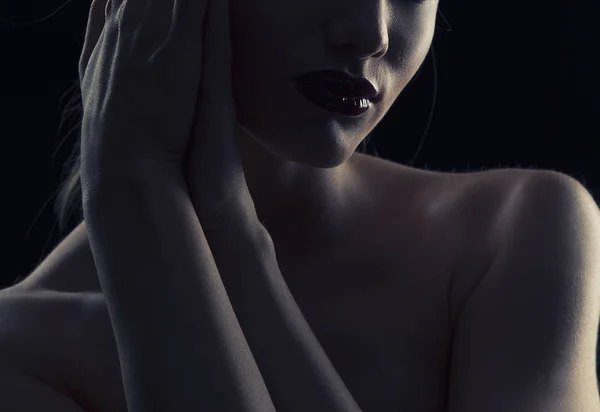 Woman portrait with dark lips in darkness