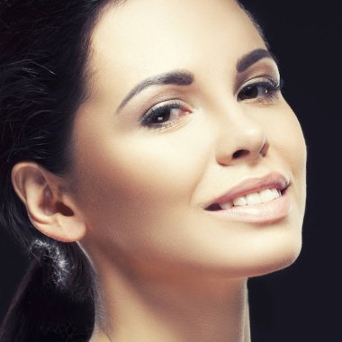 Doğal makyaj ve ihale genç esmer kadın portresi gülümsemek yüz siyah arka plan üzerinde