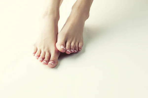 女性脚与法国修指甲的白色背景的接近的看法 — 图库照片