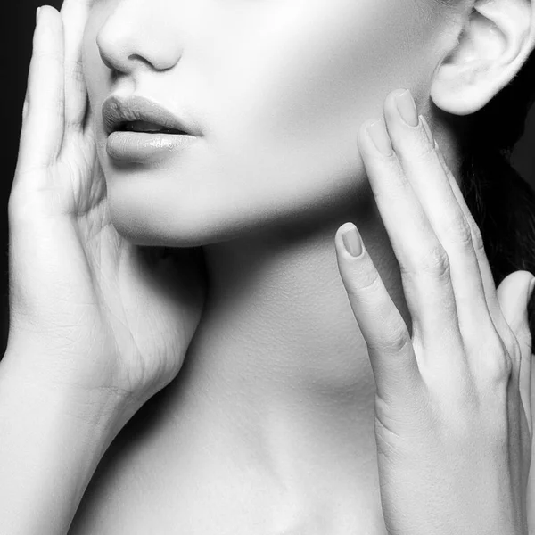 Natural lips of woman. Partial beauty portrait of young woman with perfect healthy skin, nude make-up. Monochrome