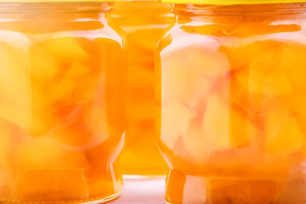Apricot jam in glass jars in the sunlight.