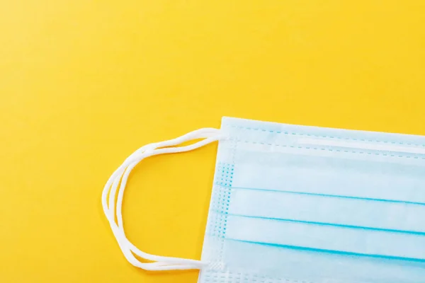 Medical mask surgical protective virus, flu, disease, textile filter. Isolated on a yellow background.