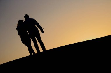 Arap çölde günbatımında iki sevgi dolu.