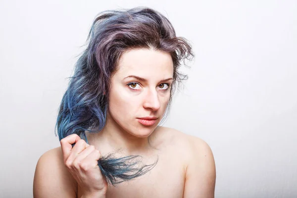 Young woman holding her colorful damaged hair in her hand — Stock Photo, Image