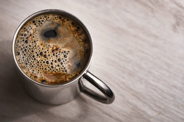 Metallic cup of instant coffee on a light wood table — Stok Foto