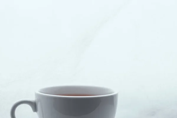 Cropped simple white cup filled with tea — Stock Photo, Image