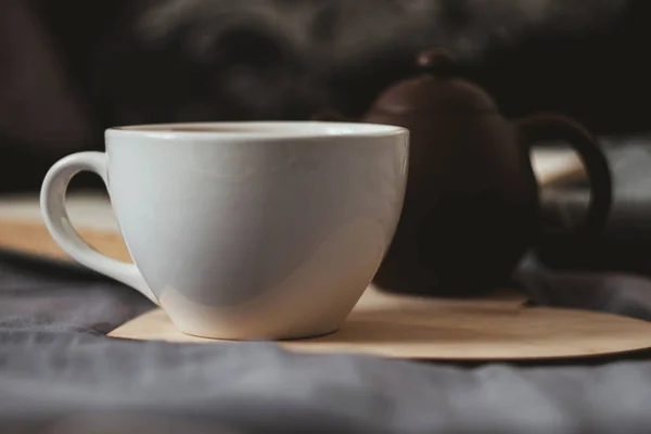 Secangkir teh dan teko teh di buku hati kayu dan syal — Stok Foto