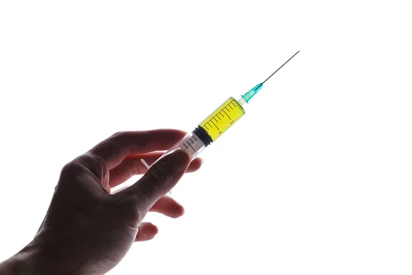 Syringe filled with green liquid held in hand — Stok fotoğraf