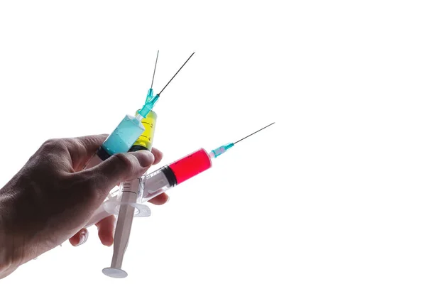 Three syringes filled with bright liquids held in one hand — Stock Fotó