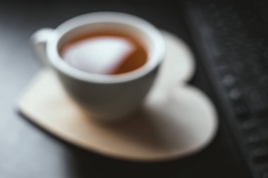 Kalp şeklinde ahşap tabakta bulanık beyaz çay fincanı