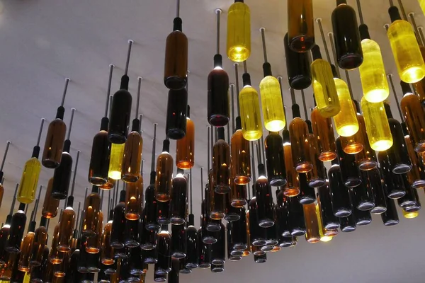 Creative reuse of wine bottles as lamps installed on the ceiling