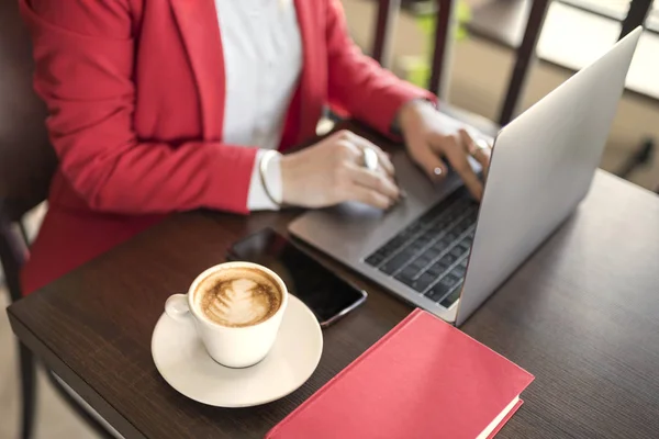 İş kadın kapalı kahve ve ahşap masa üstünde laptop