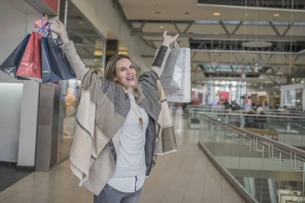 Посміхається дівчина з сумками в торговий центр — стокове фото