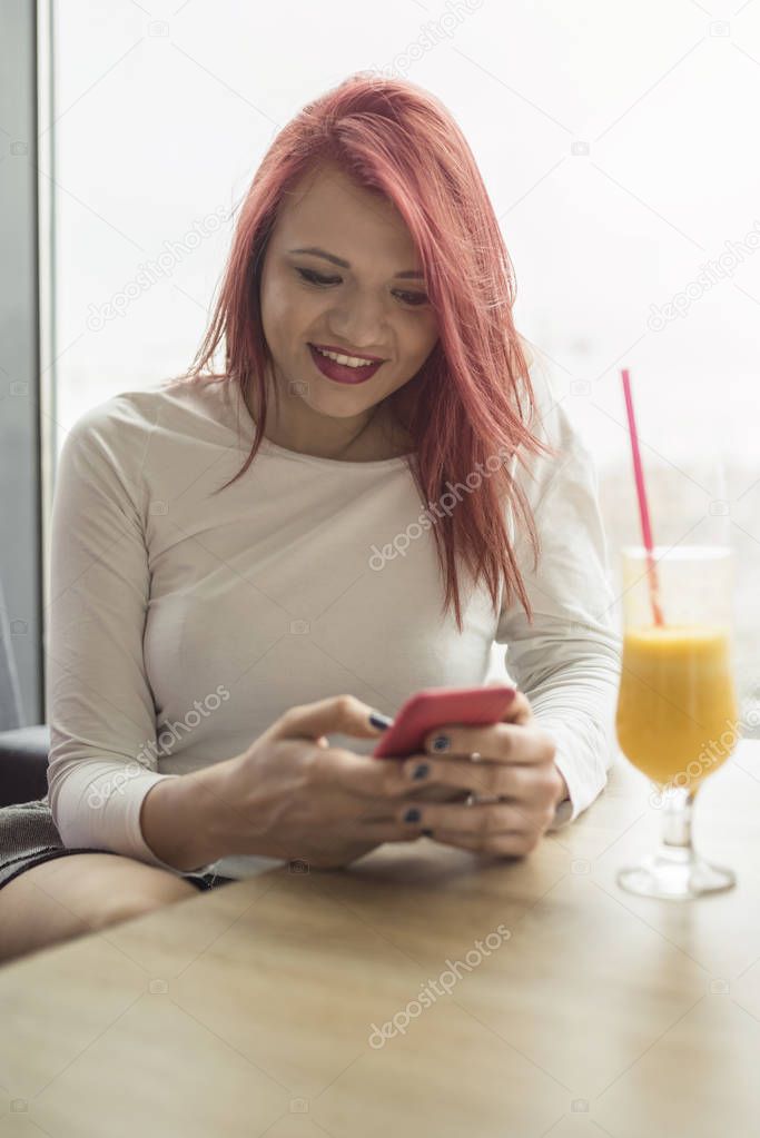 Portrait of young beautiful woman using mobile phone at coffee s