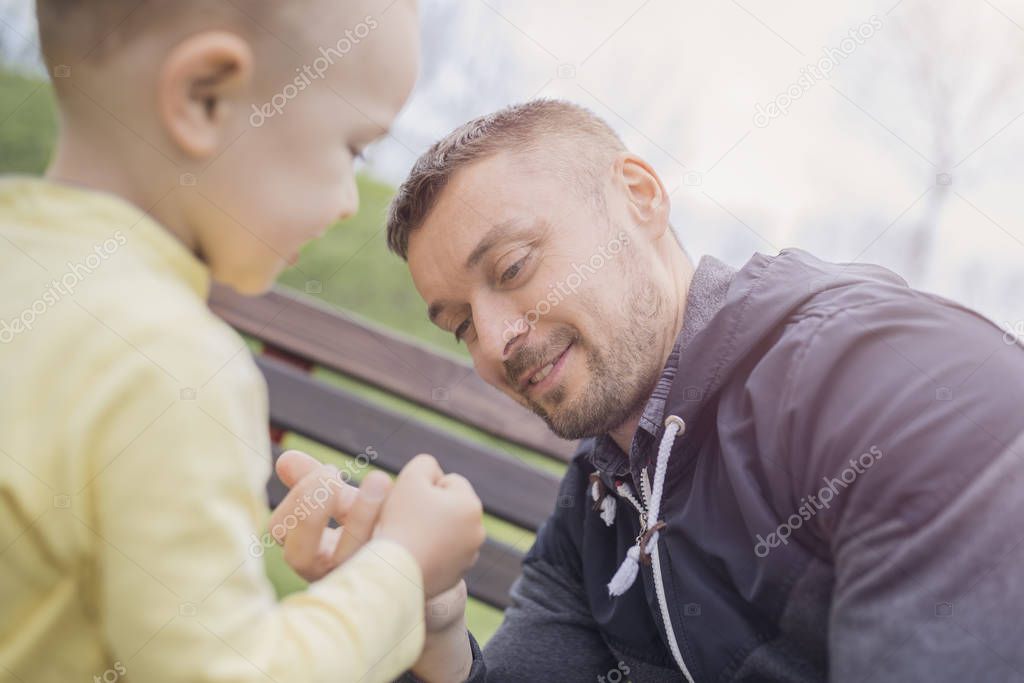 Closeup portrait of a happy father and son playing on playground