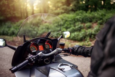 Ormanda motosiklet süren bir sürücü. Motosikletli bir adam sokakta gezintiye hazırlanıyor.. 