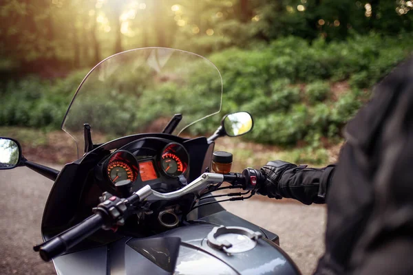 Ormanda motosiklet süren bir sürücü. Motosikletli bir adam sokakta gezintiye hazırlanıyor.. 