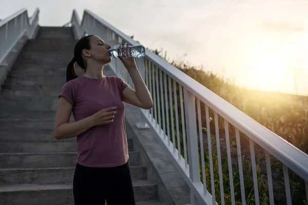 Gün batımı egzersizi güzel, sporcu kadınla. Kadın fitness koşusu, spor sağlık konsepti. Koşu yaparken müzik dinleyen kadın koşucu