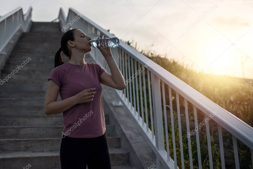 Sunset exercise with beautiful, sport woman. Woman fitness jogging, workout wellness concept. Female runner listening to music while jogging