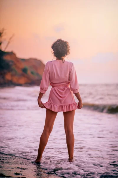 해변에서 드레스를 소녀의 실루엣 새벽을 배경으로 — 스톡 사진