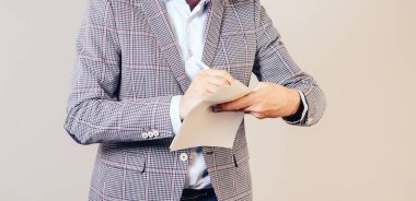 Bir adam elindeki belgeleri tutar ve bir imza atar. İş hayatında başarı kavramı.