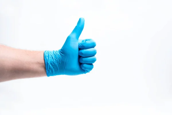 Een mensenhand in een blauwe rubberen handschoen met opgeheven vinger. — Stockfoto