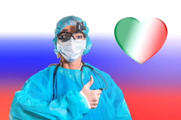A female doctor raises her finger approvingly against the background of the Russian flag and a heart of Italian flowers. The concept of friendship from Russia with love, assistance during the pandemic
