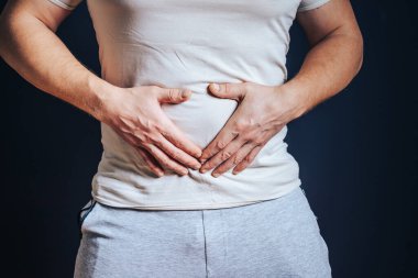 Adam ellerini karnına dayıyor. Mide rahatsızlığı, şiddetli ağrı, hazımsızlık, şişkinlik..